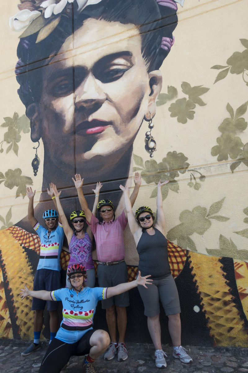Participants and  owners of the Fat Bike Graffiti and Art Tour posing in front of a  three story high mural of Frida Kahlo. : PUERTO VALLARTA - Wall Art & Bicycle Tour : Viviane Moos |  Documentary Photographer