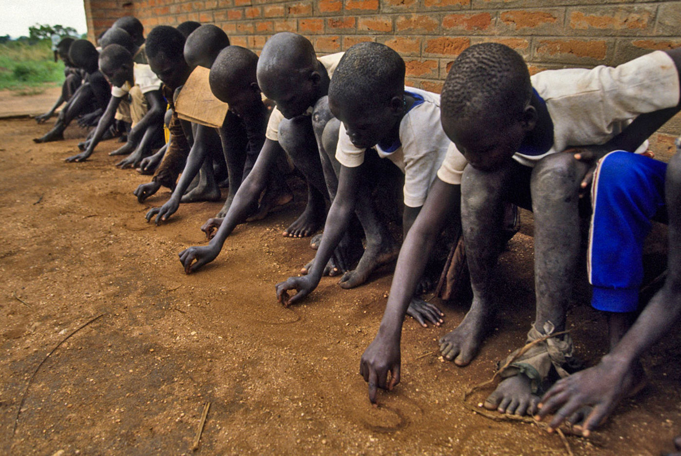 Their schools destroyed, no paper or pencils available, children  make do with learning to write in the sand. : CRISIS : Viviane Moos |  Documentary Photographer