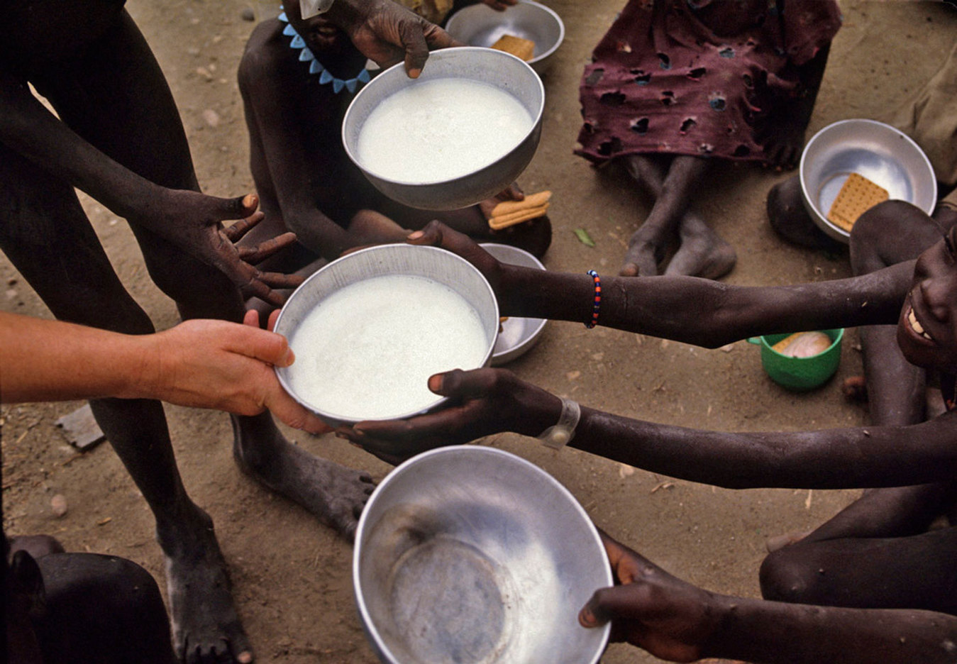 Distributing milk to children in a food distribution center in Southern Sudan : CRISIS : Viviane Moos |  Documentary Photographer