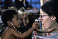 Earning trust - a doctor allows her young refugee patient to examine her. Thai - Cambodian border. - © Viviane Moos