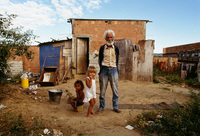A grandfather with his grandchildren in front of their home, Brazil - © Viviane Moos