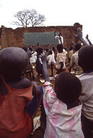 Their schools destroyed, children and teachers make do with a standing wall and black board - © Viviane Moos