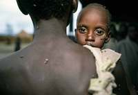 A father brings his sick son to a day-lift medical center in Southern Sudan  - © Viviane Moos