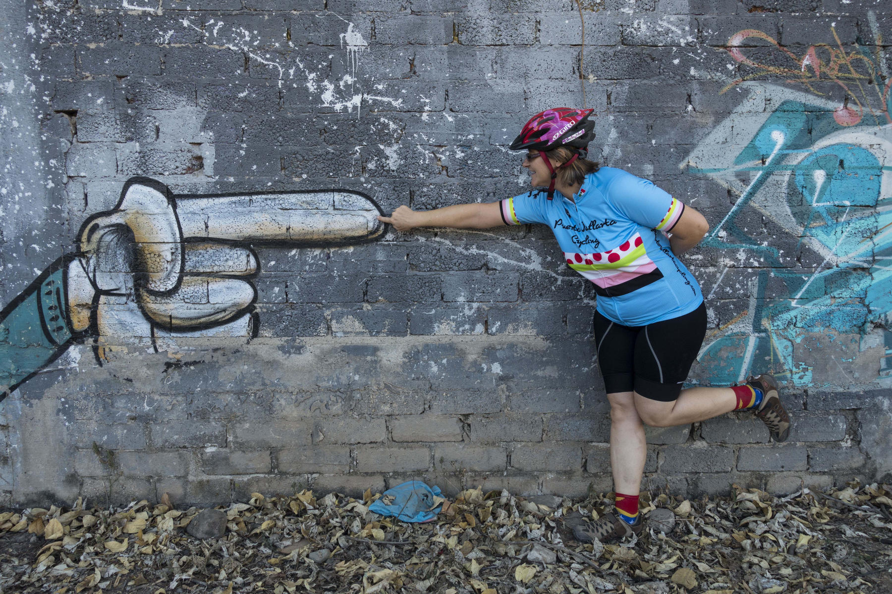 Carmen, owner of Puerto Vallarta Cycling, connecting  with a  painted pug dog's finger
 : PUERTO VALLARTA - Wall Art & Bicycle Tour : Viviane Moos |  Documentary Photographer