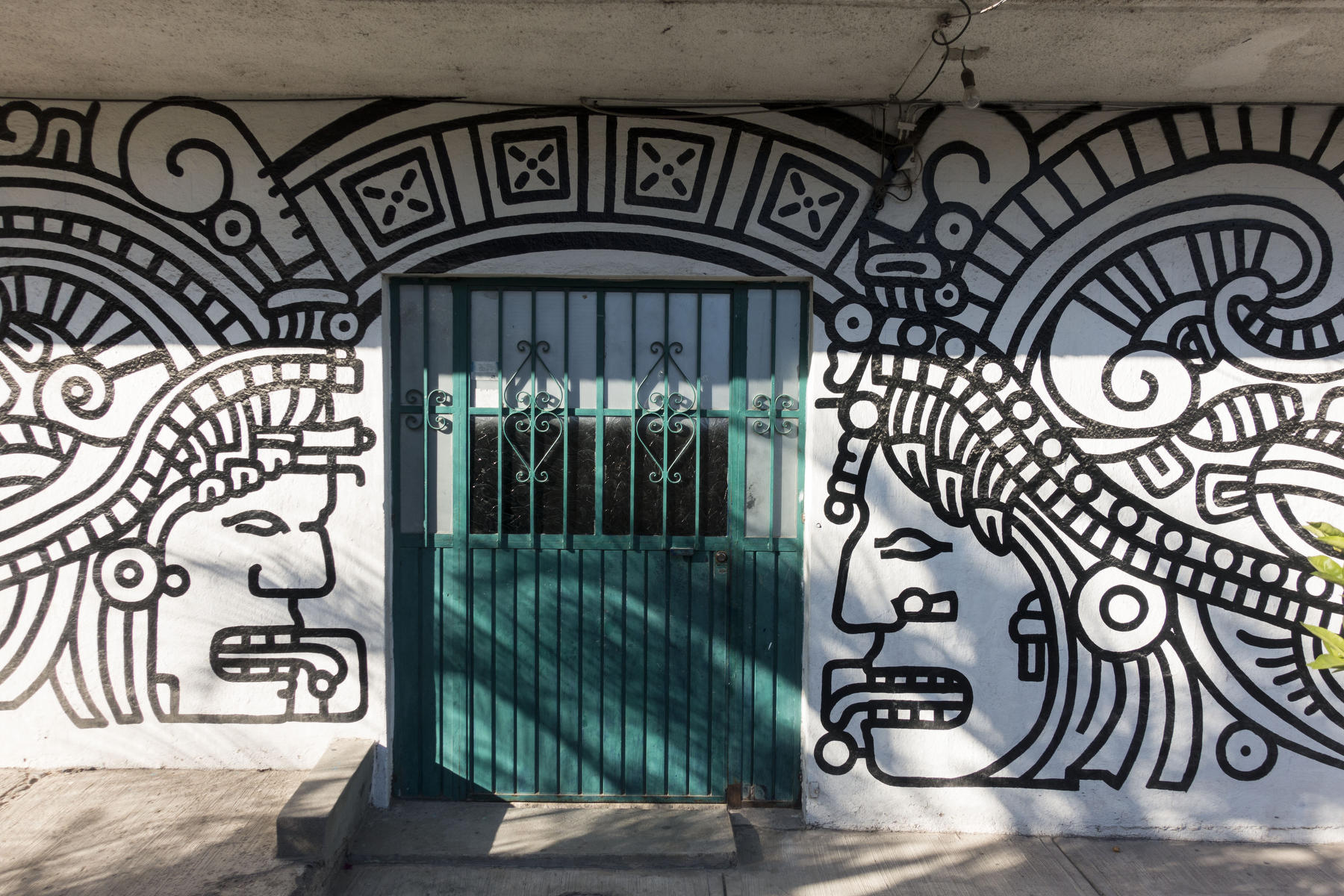 Classical stylized Mayan warriors decorate the  front of a private house. : PUERTO VALLARTA - Wall Art & Bicycle Tour : Viviane Moos |  Documentary Photographer