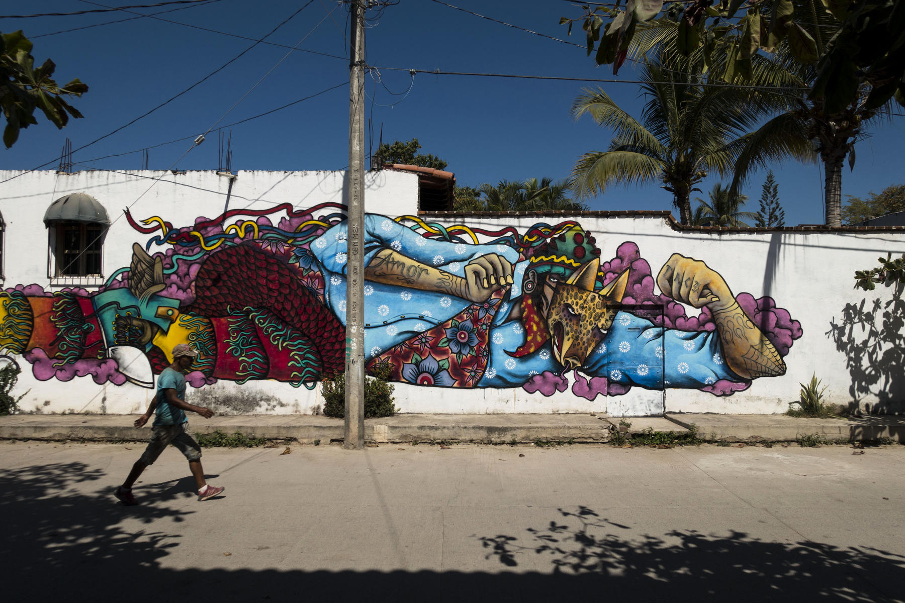 Powerful image of a man wearing a leopard mask with tattoos of spider webs and the word Love on his arm : PUERTO VALLARTA - Wall Art & Bicycle Tour : Viviane Moos |  Documentary Photographer