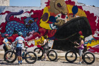 Participants and the owners of Puerto Vallarta Cycling  in front of a work in progress mural - © Viviane Moos